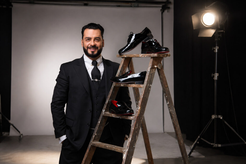 Fabio en el estudio, junto a una escalera con zapatos de charol negro de la casa